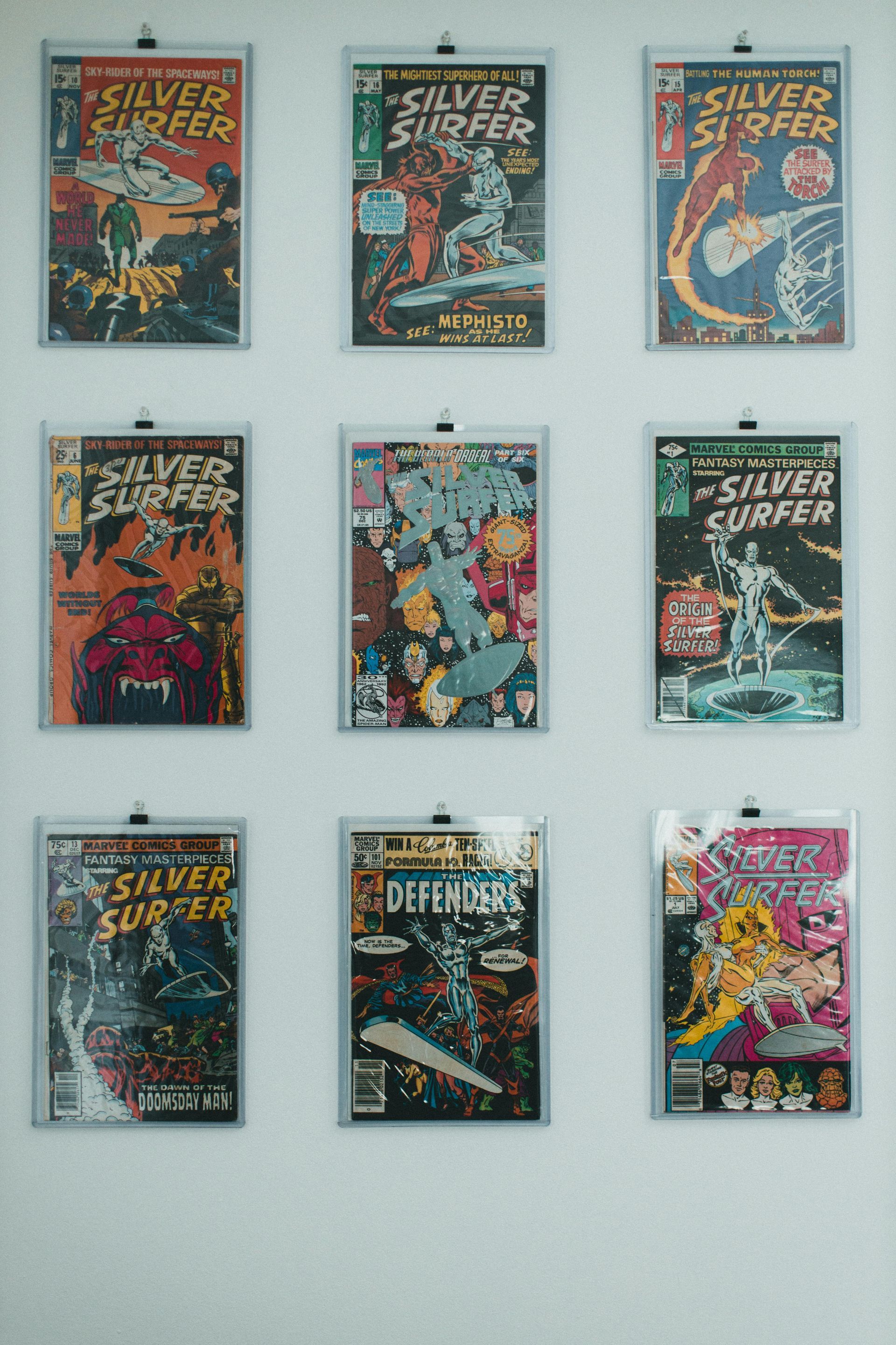 Nine comic book covers displayed in a 3x3 grid against a light wall.