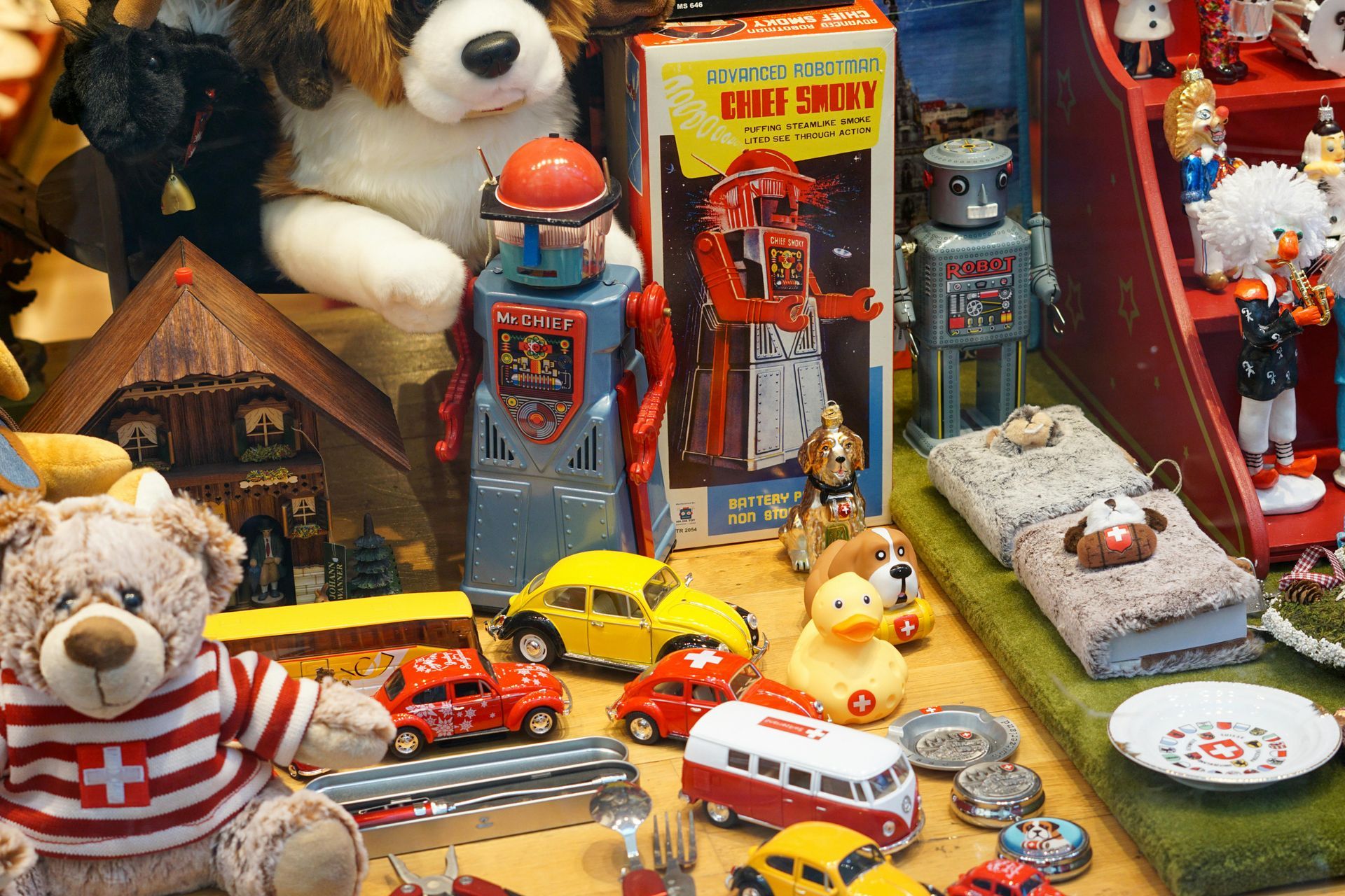 Teddy bear toy display with colorful miniature cars, buildings, and a red-and-white rocket stand