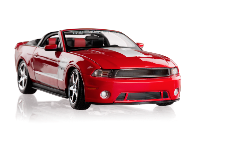 Red Ford Mustang convertible against a white backdrop.