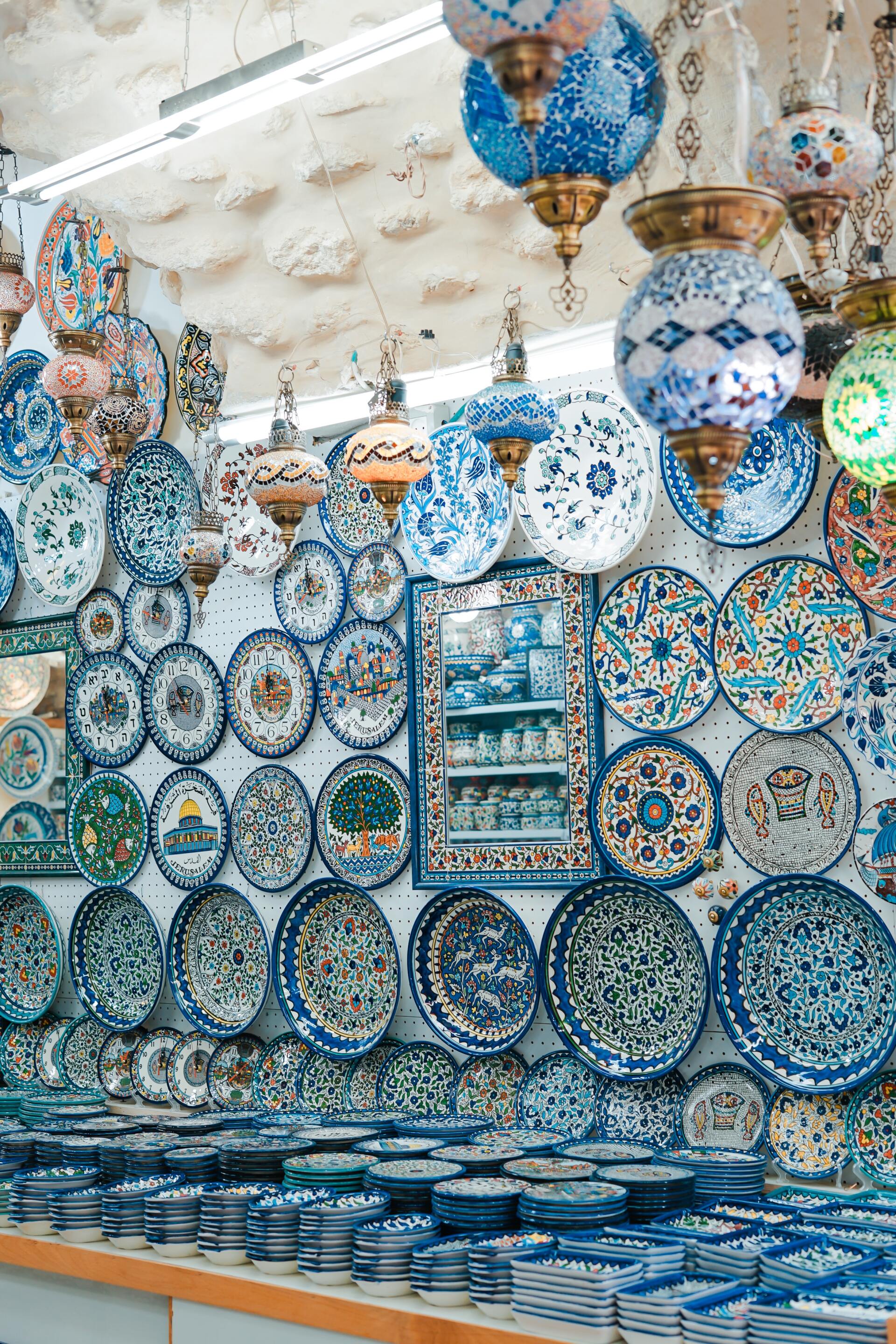 Display of blue and white ceramic plates and hanging lamps.