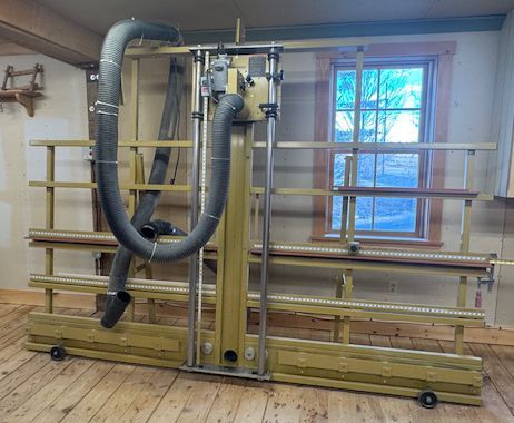 Wooden workshop machine with large gray dust hoses.