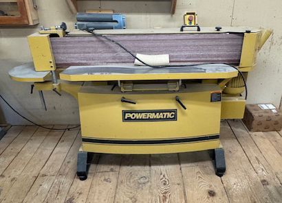 Yellow Powermatic woodworking jointer-planer in a shop.