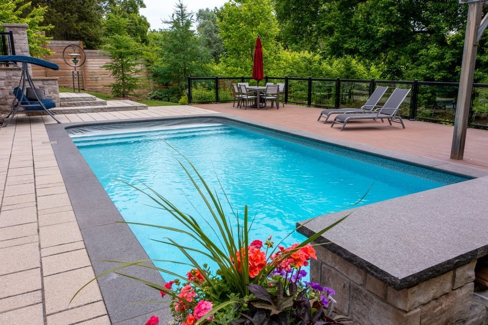 There is a large swimming pool in the backyard with a blue umbrella.