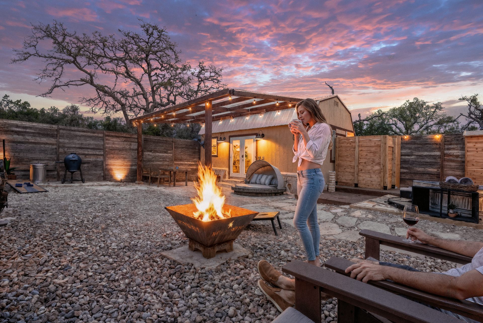 Guest tending the Quiroga fire pit beneath a Hill Country sunset