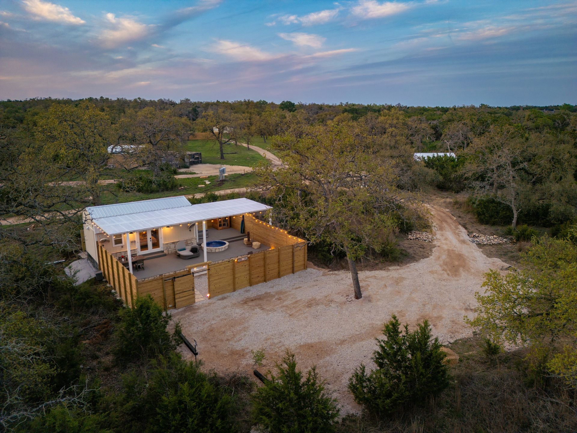 Aerial view of Alebrije cabin and its private fenced yard among oak trees