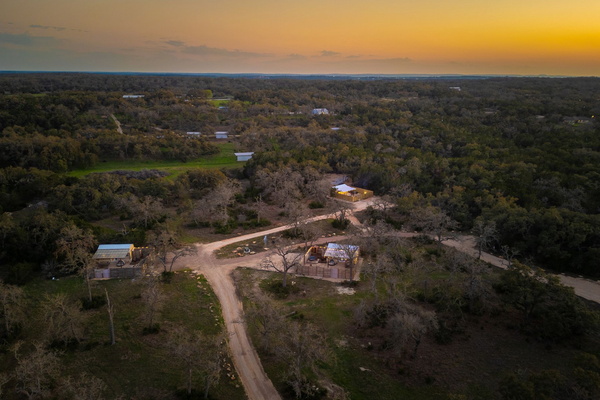 Aerial view across Avandaro Ranch and its oak-covered Hill Country setting at sunset