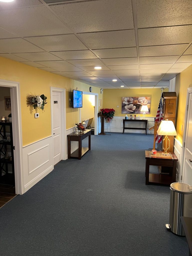 Hallway with blue carpet, yellow walls, and decorative accents.
