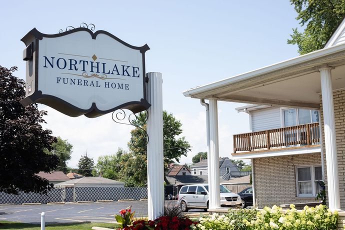 Sign for Northlake Funeral Home, near a white building with porch.