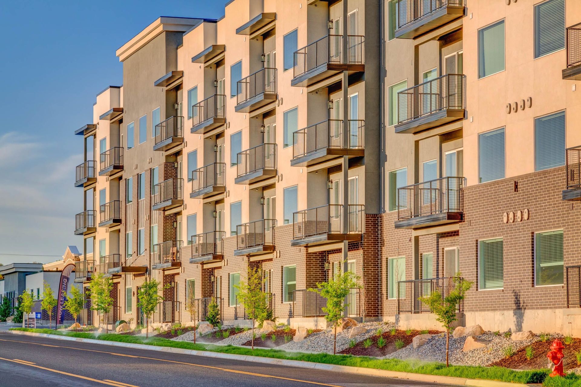 A large apartment building with a lot of balconies on the side of the road.