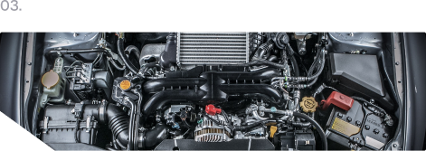 Car engine bay with black components and red center cap, viewed from above