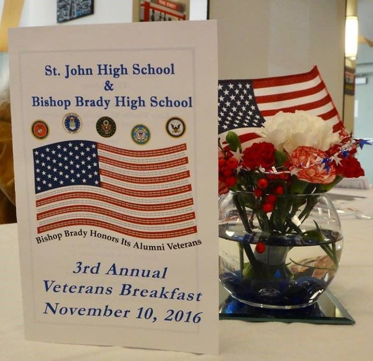 image of decorated table for veterals with american flag, bouquet of flowers