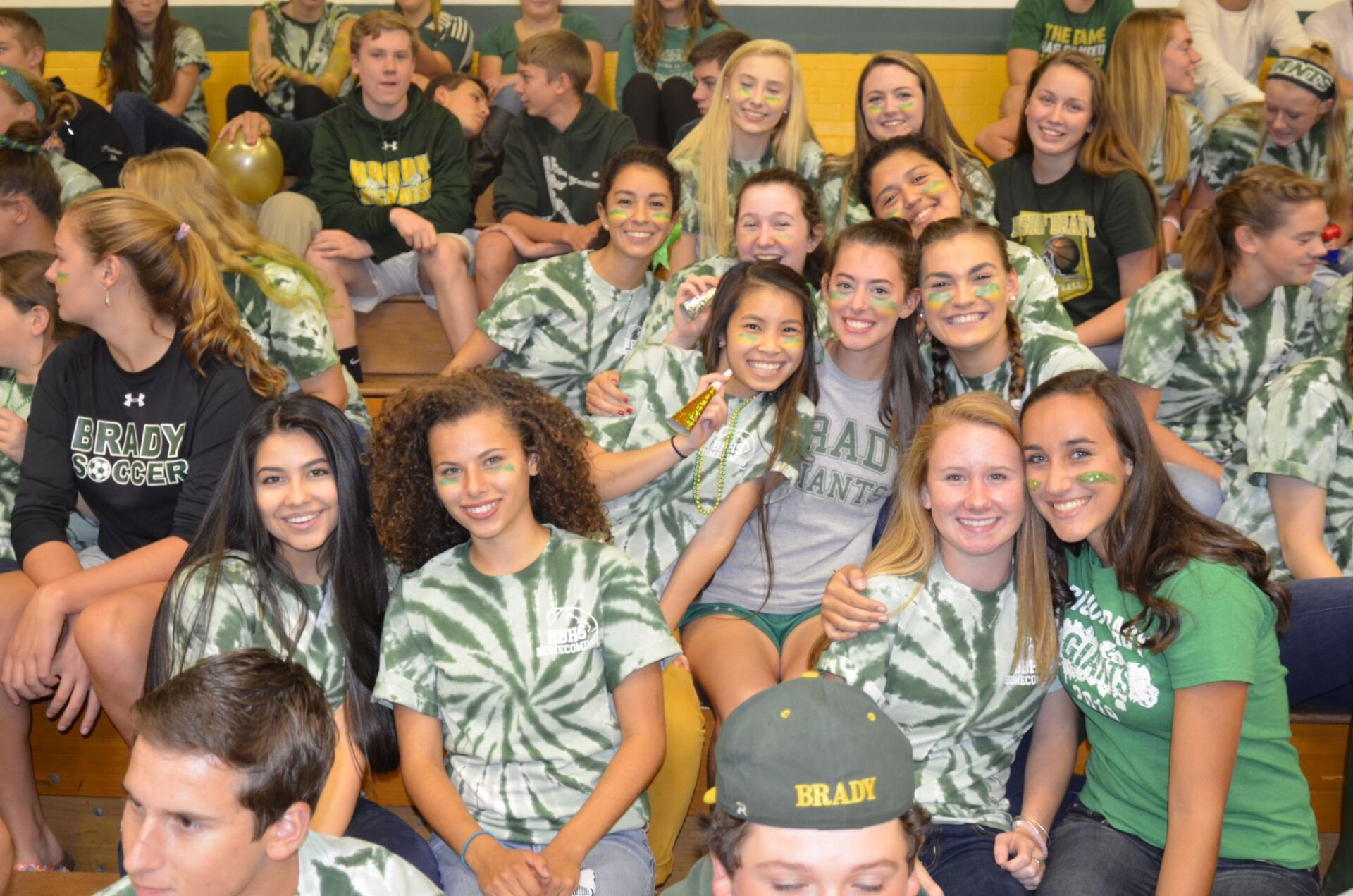 group of students smiling sitting on bleachers