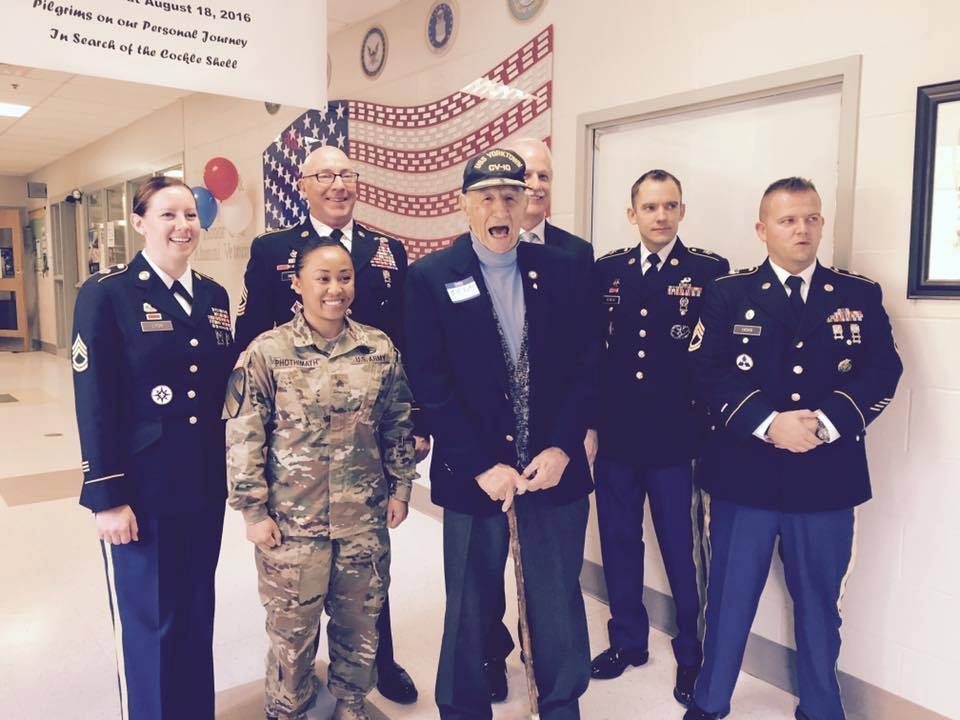 Military people standing in hallway with american flag in background