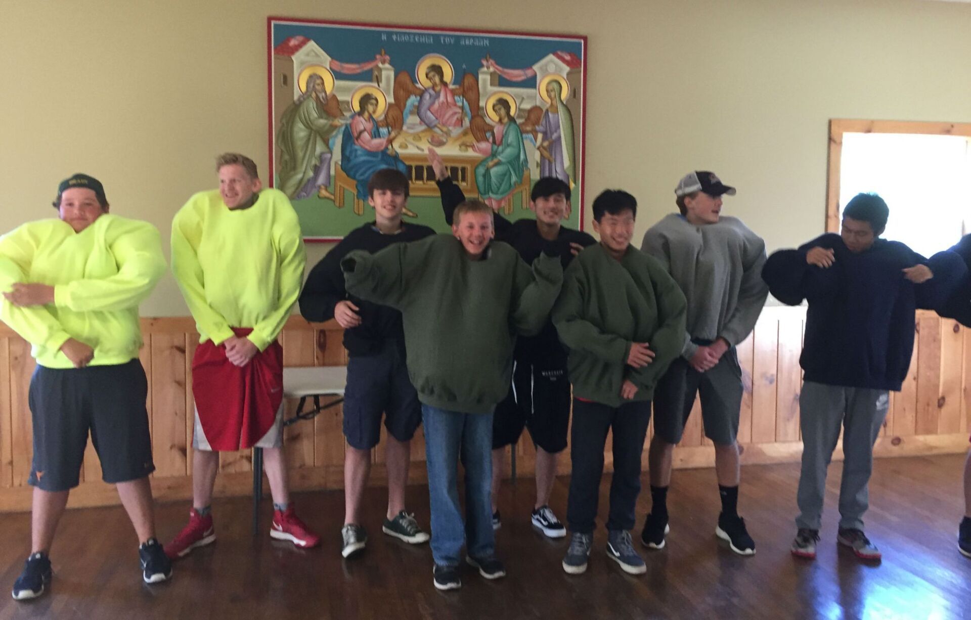 group of students wearing sweatshirts inside a building 