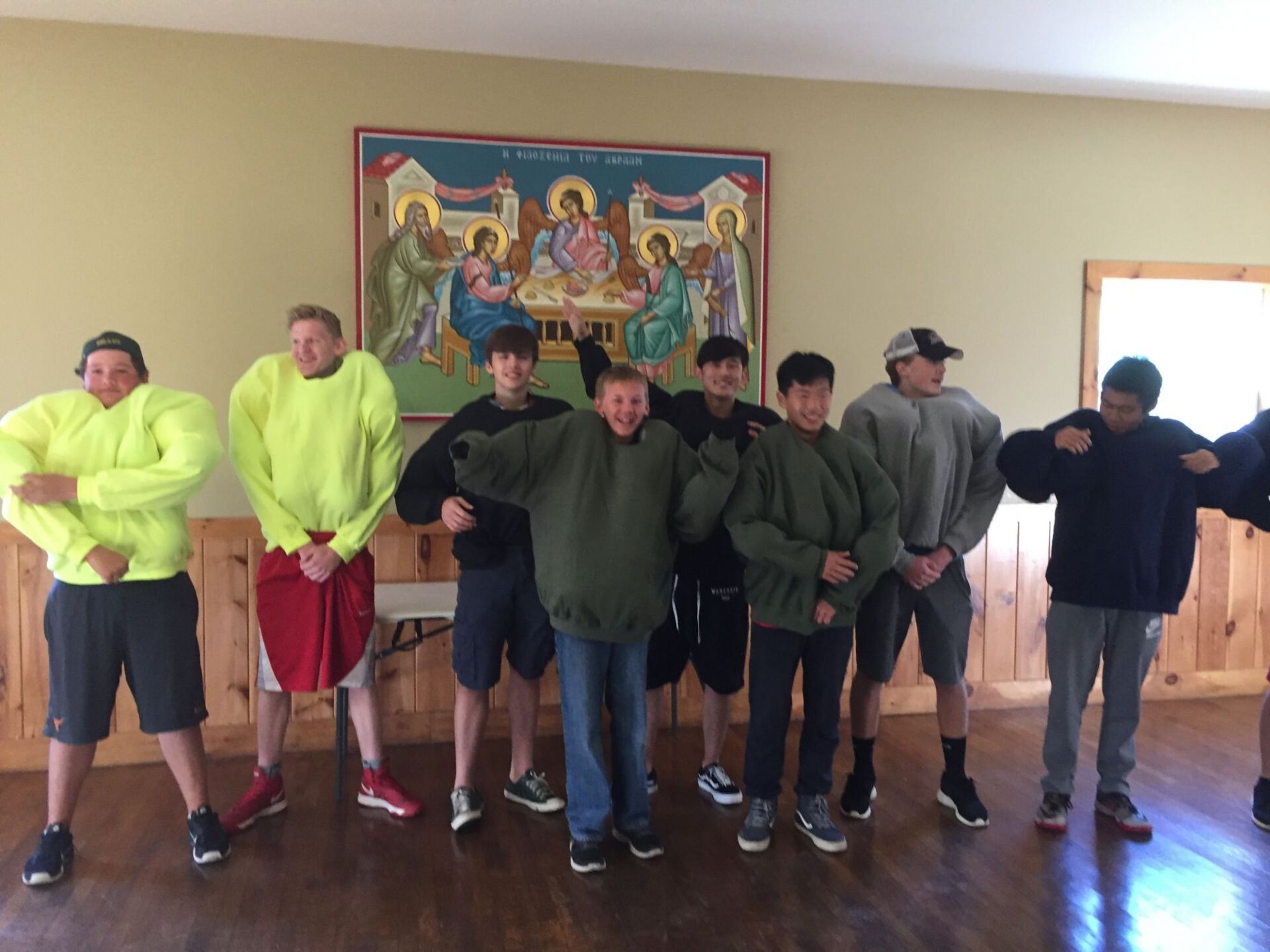 group of students wearing sweatshirts inside a building 