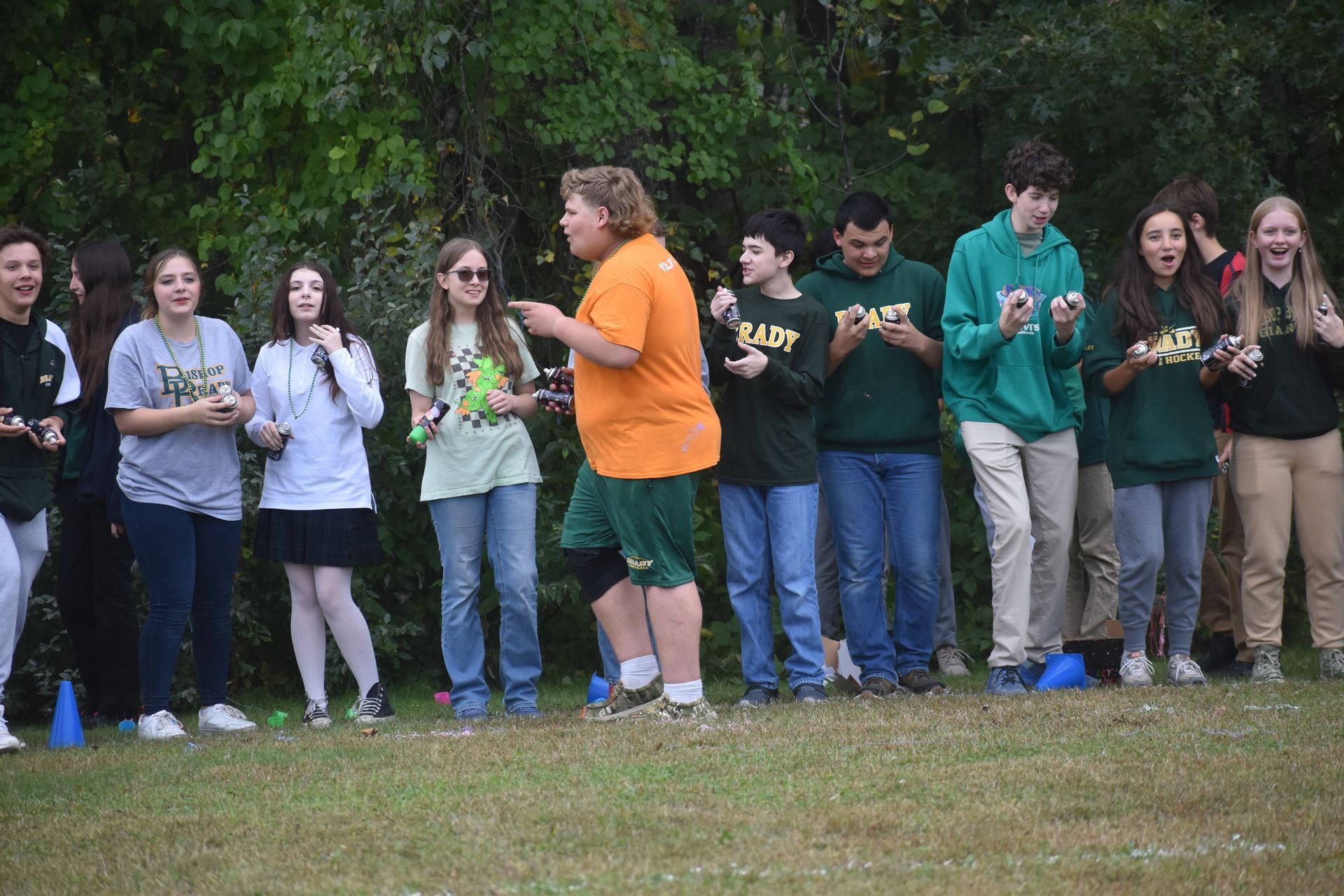 group of students lined up in front of trees playing a game