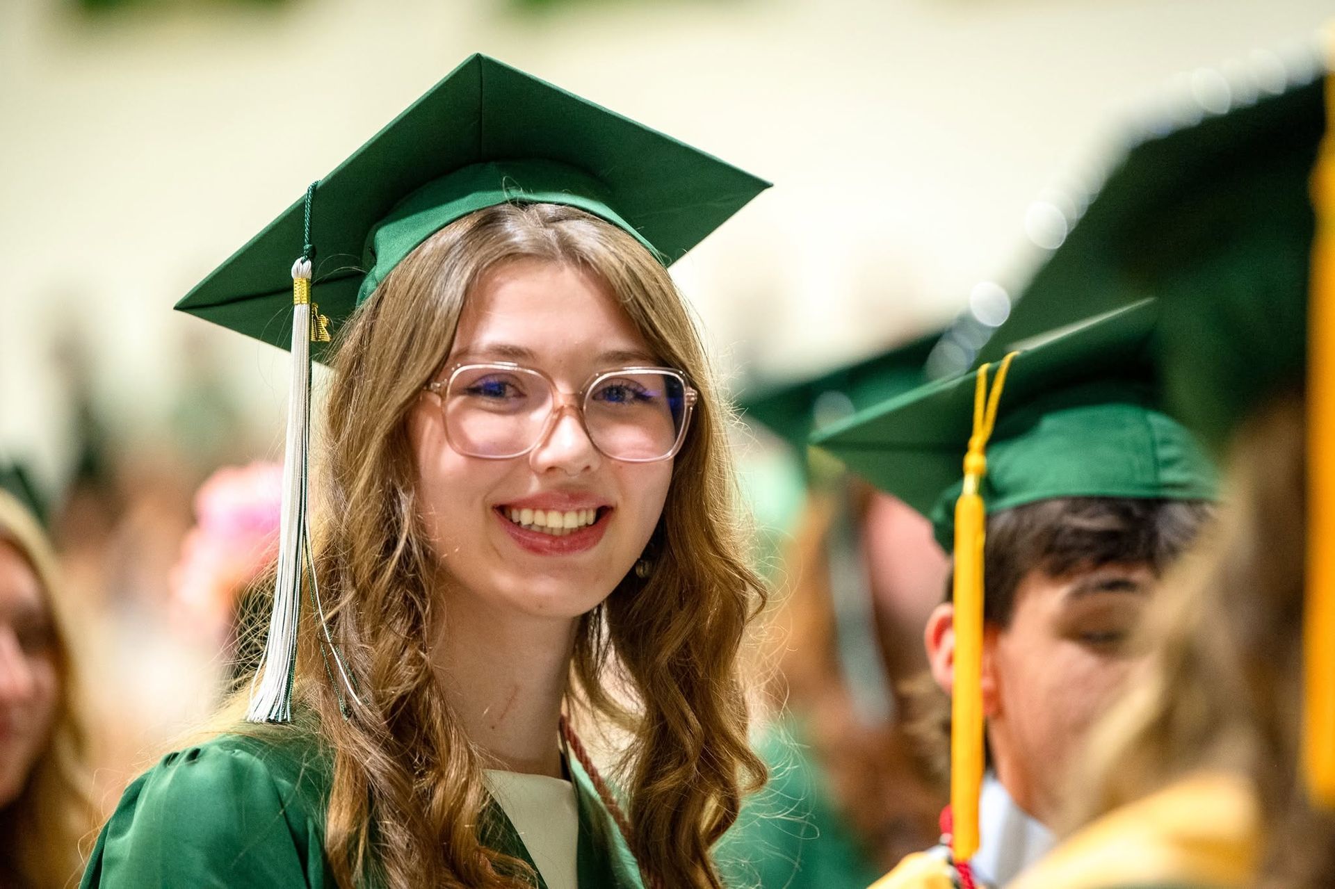 female in cap and gown, smiling