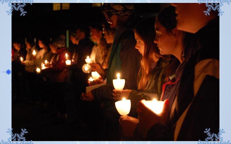group of students holding lit candels outside
