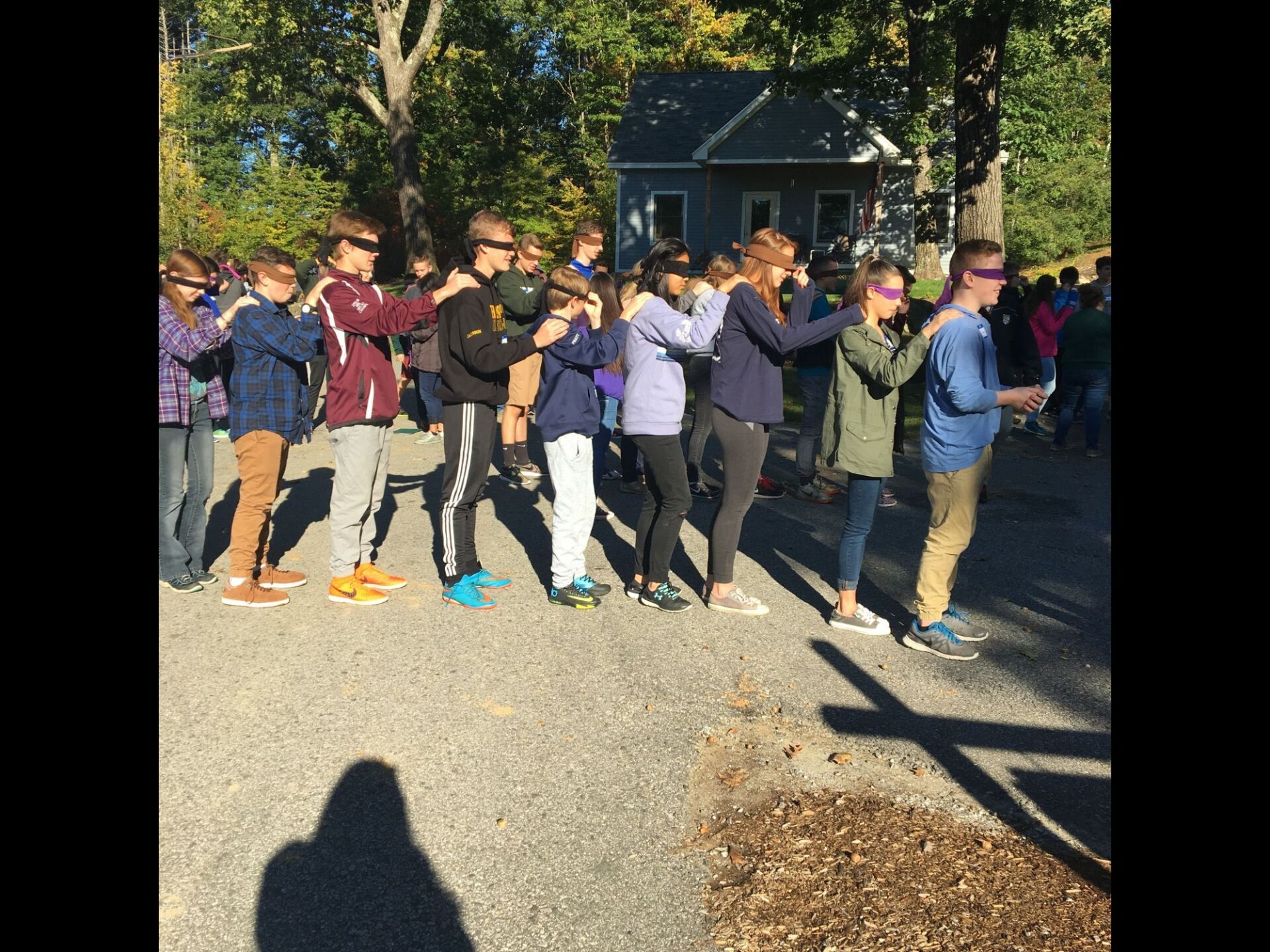 group of students outside with blindfolds on playing a game