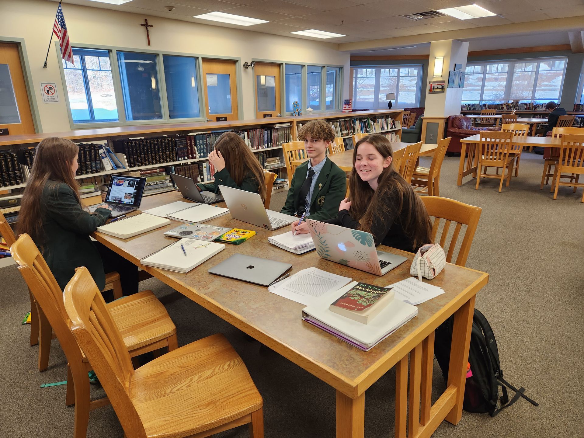 students in the library at a desk 