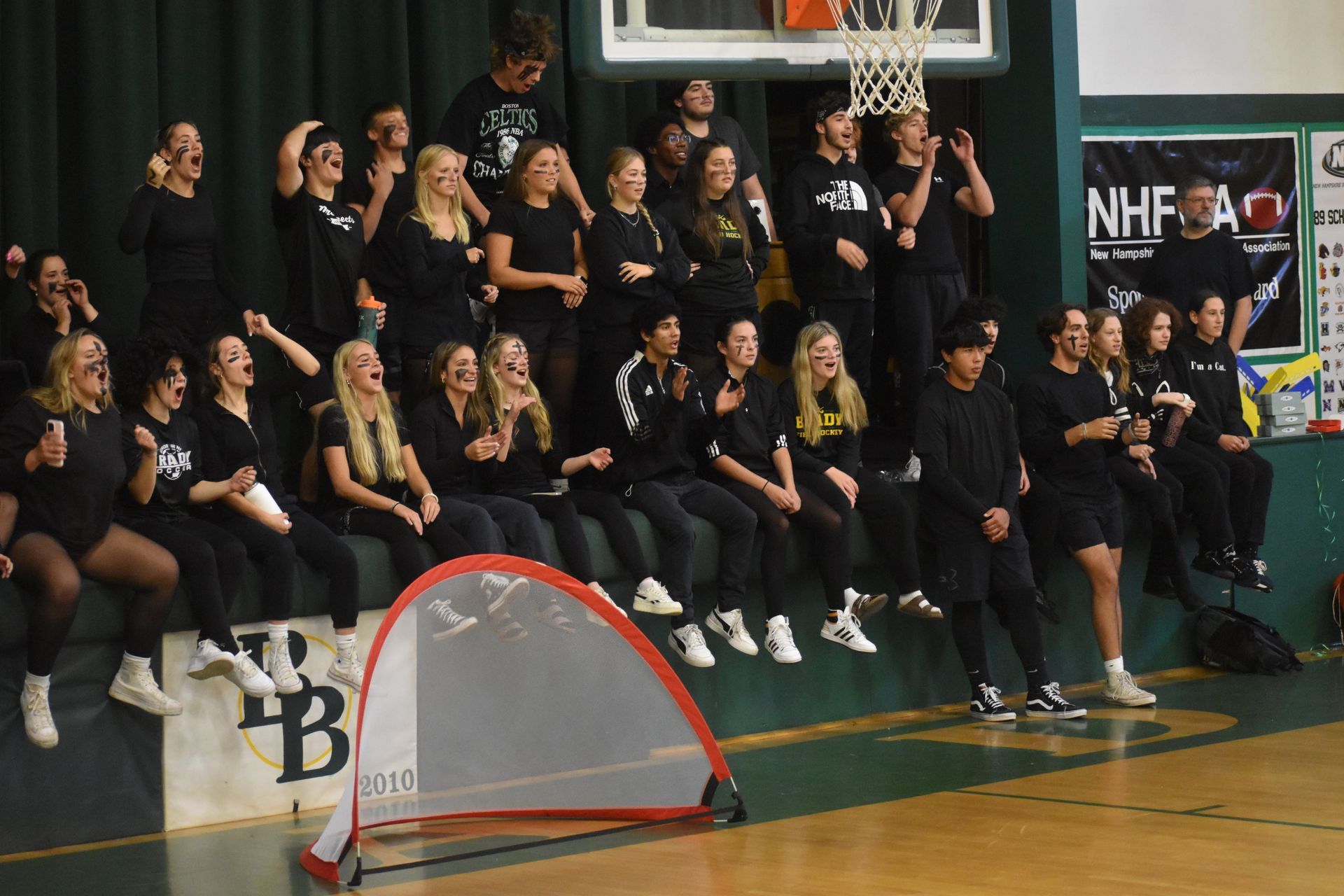 Group of students in the high school gym, smiling and clapping