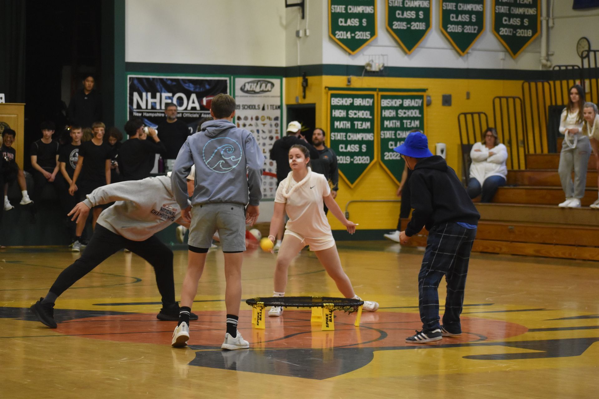 group of 4 students playing with a yellow ball in the gym 