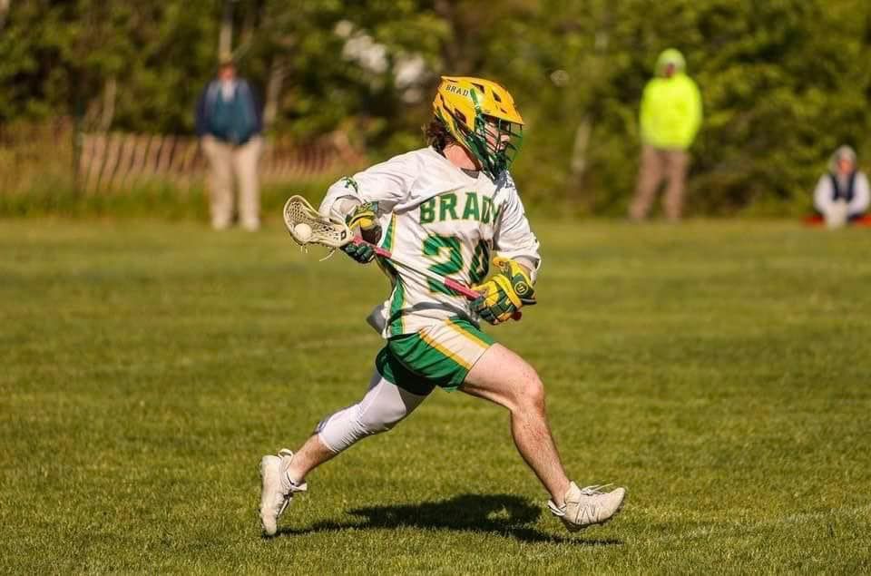 running male lacross player on a field 