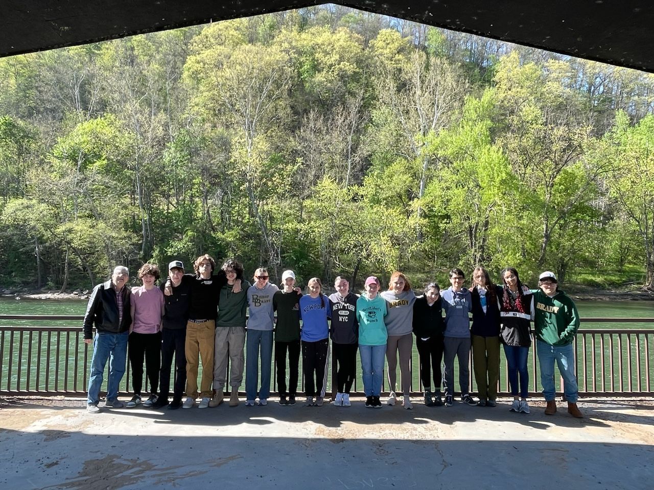 students standing by water smiling in a group
