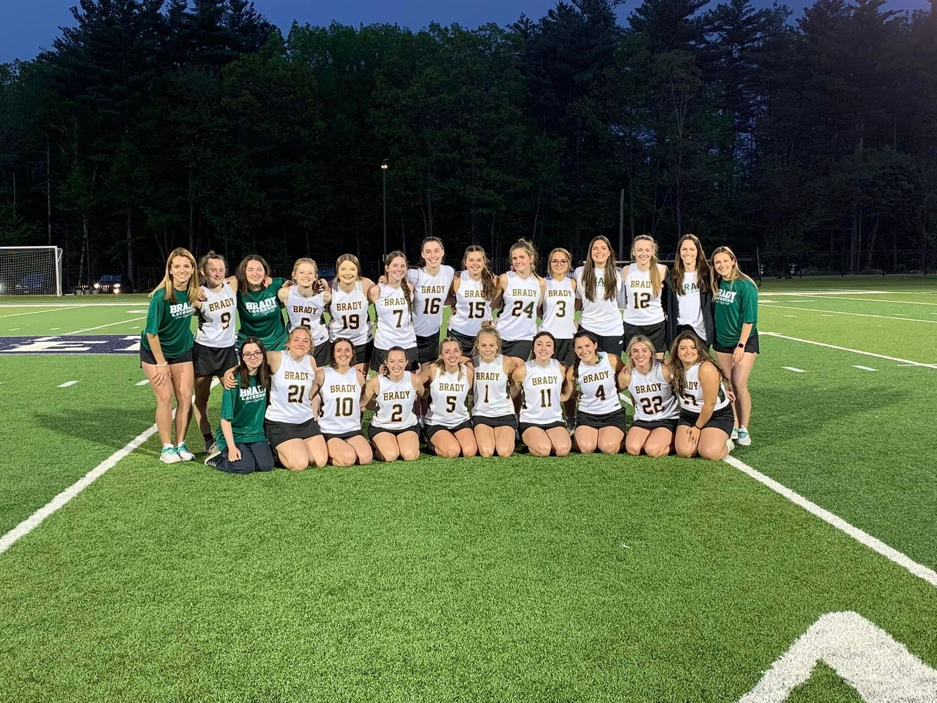 womens soccer team photo outside on field at night