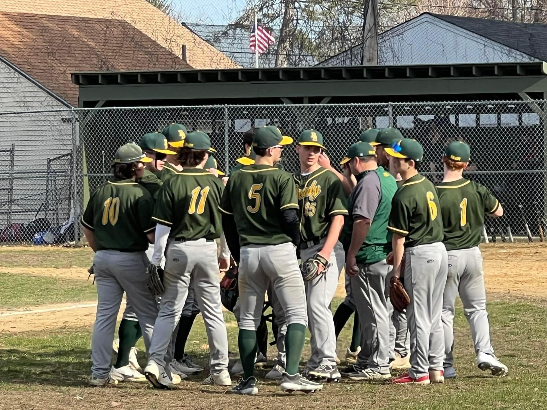 a group of baseball player in school jerseys in a huddle