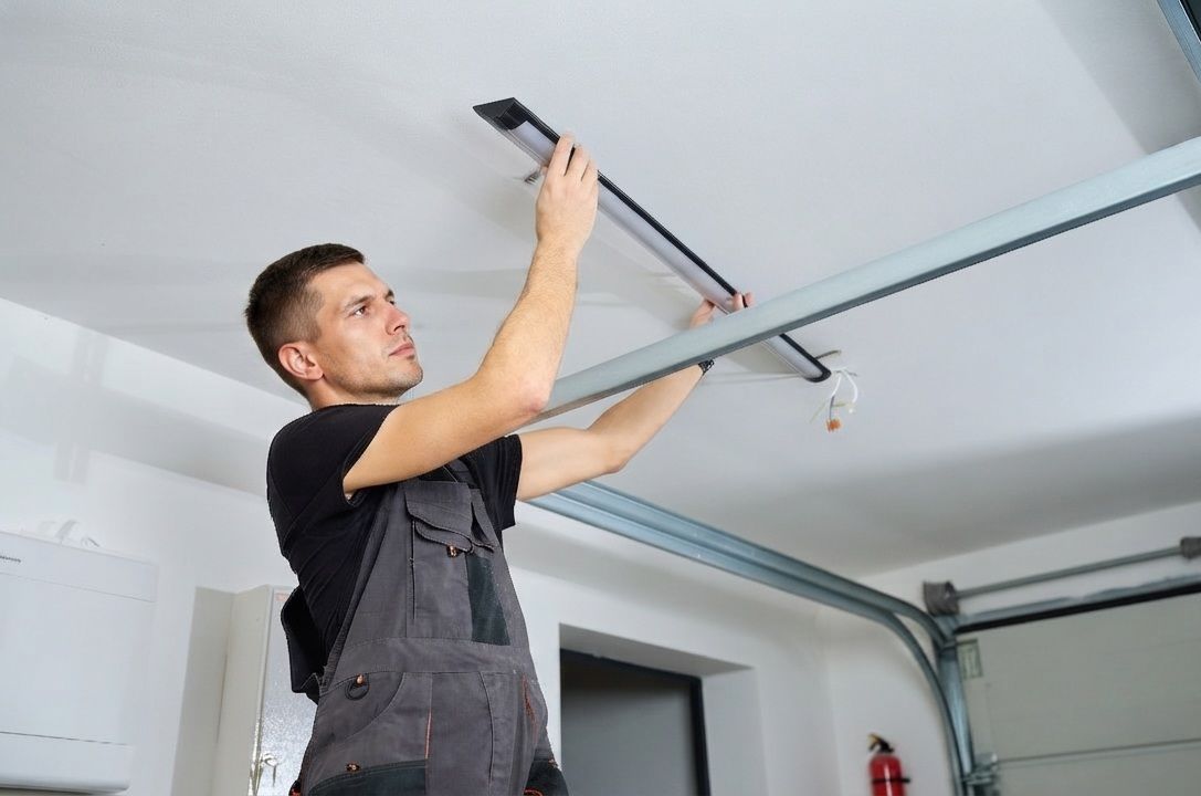 Technician diagnosing a garage door opener at a Tulare, CA residence
