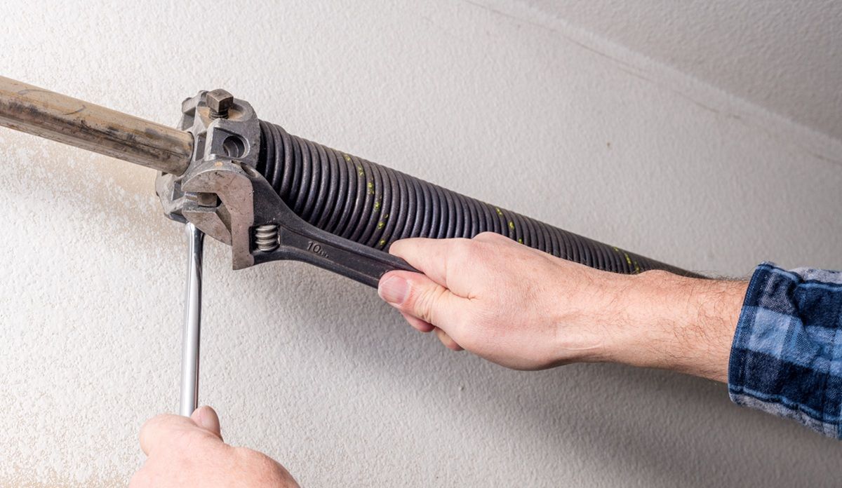 Technician inspecting common garage door problems at a Tulare home