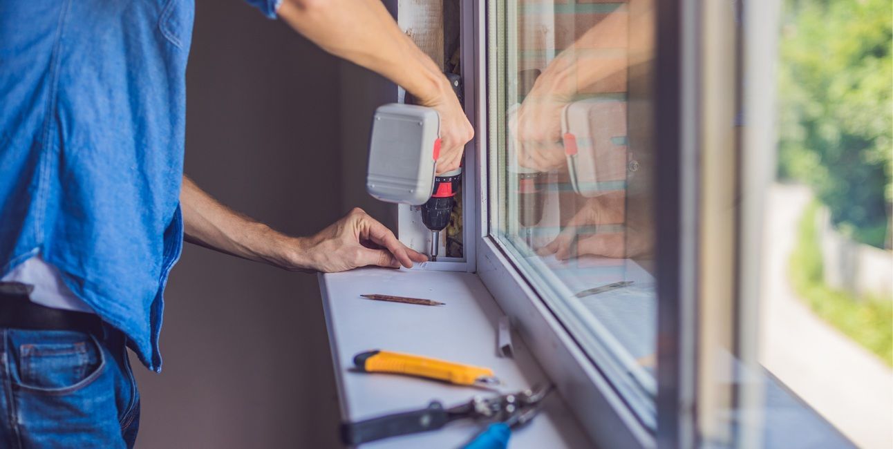 Professional window installer fitting a replacement unit in Tulare, CA