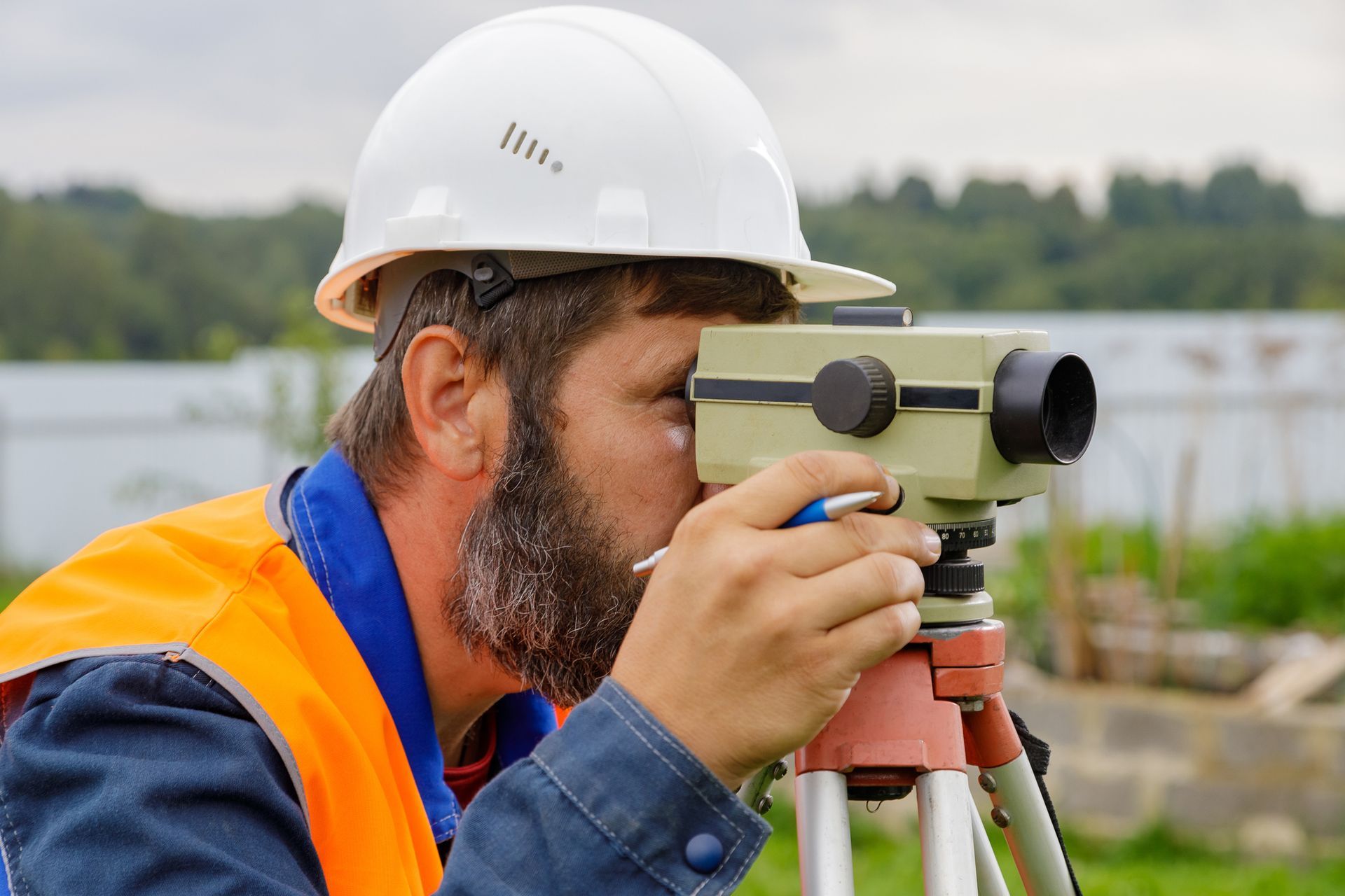 A man in a hard hat is looking through a telescope.