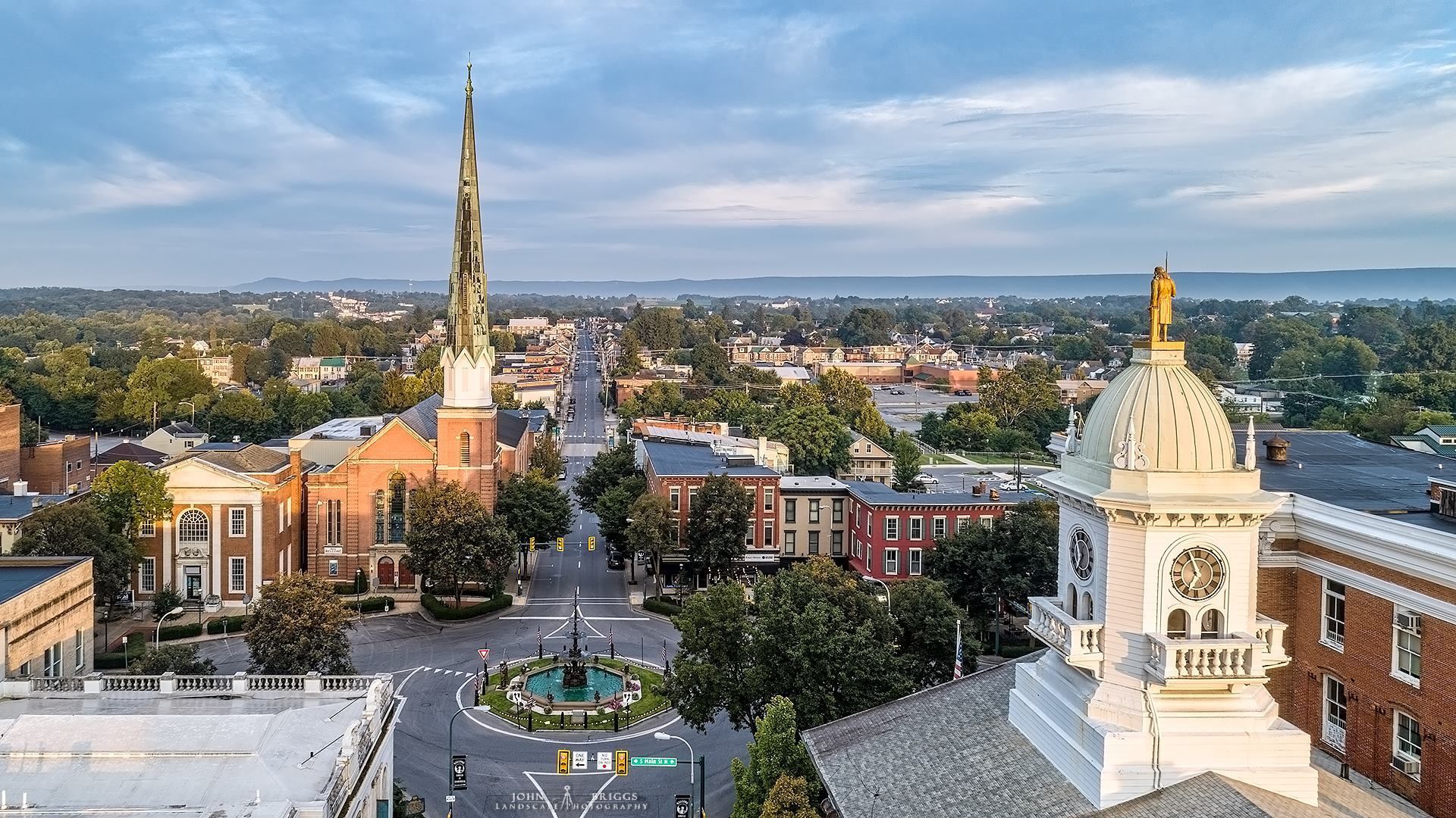An aerial view of a city with a clock tower and a church. An aerial view of a city with a clock tower and a church.