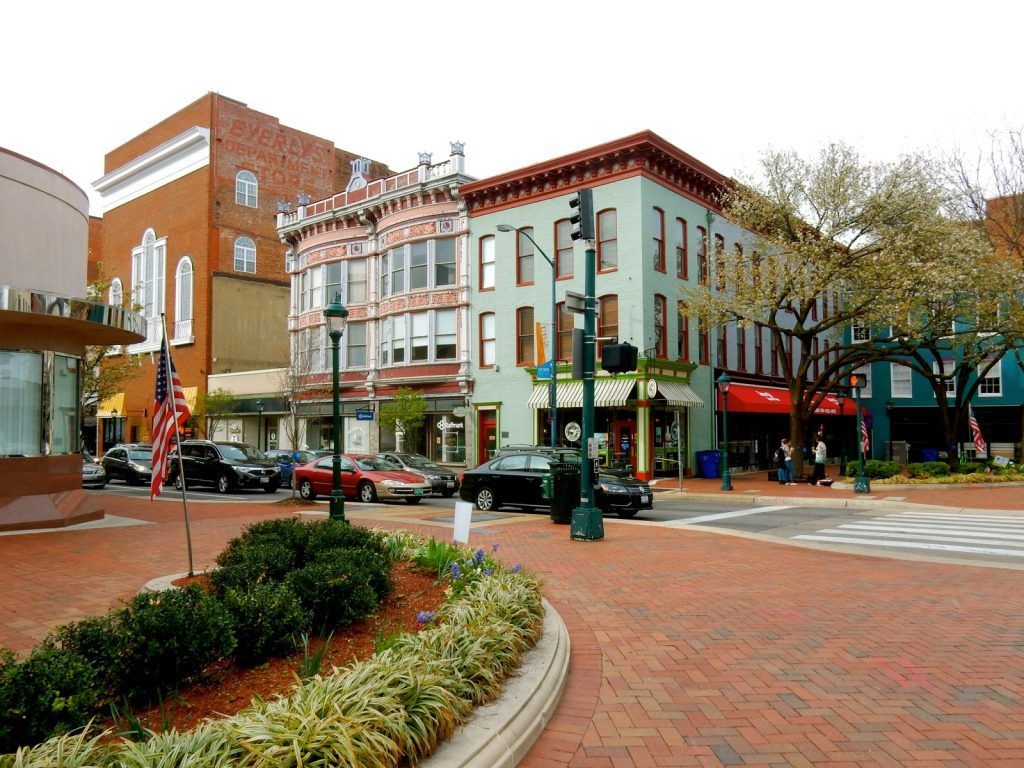 A city street with a green building in the middle A city street with a green building in the middle