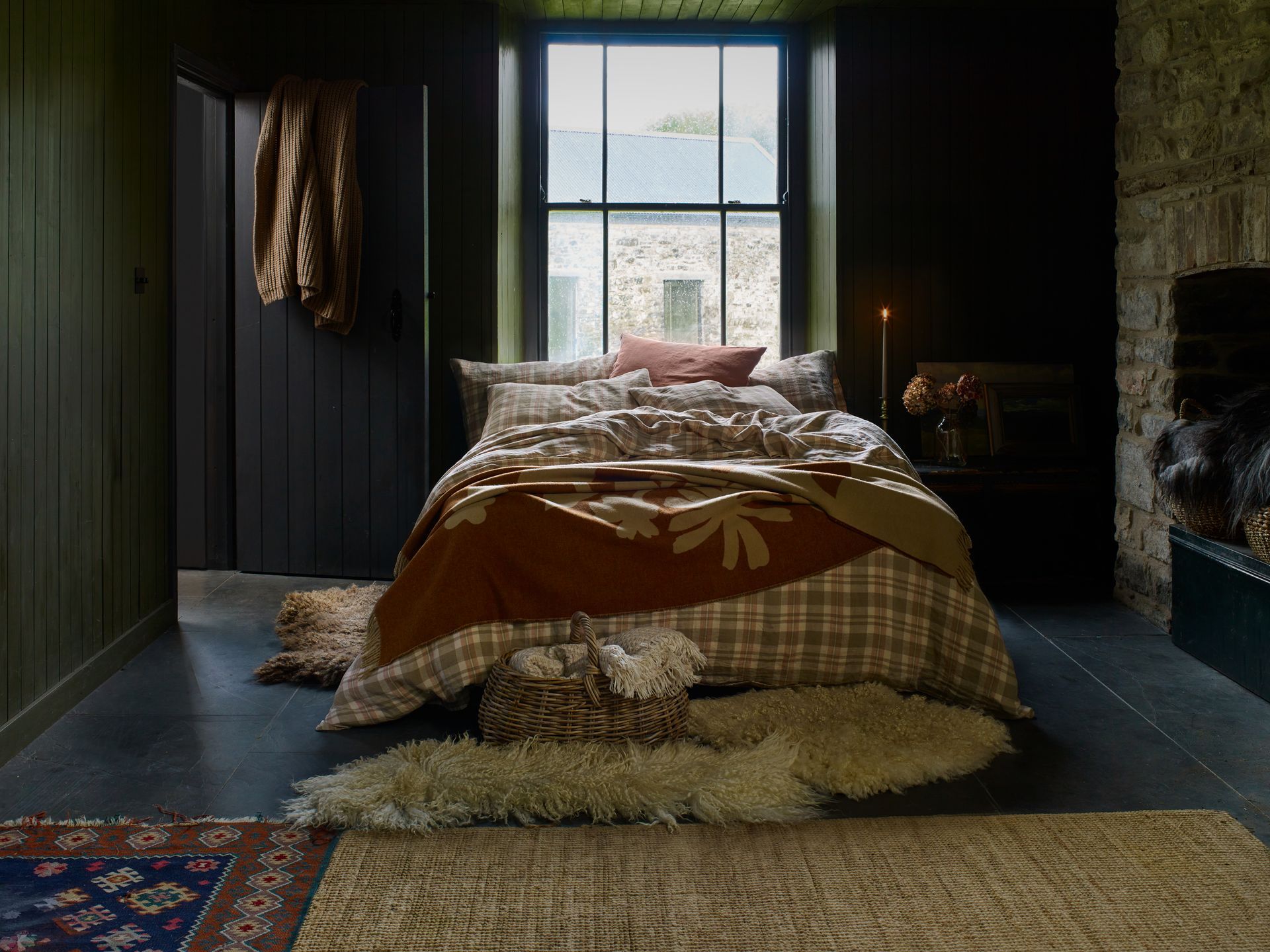 Bedroom styled with Piglet in Bed linen bedding featuring three felted fleece rugs, two handcrafted by Deborah Griffin and one by felt artist Karolina Begier, in a rustic country interior.