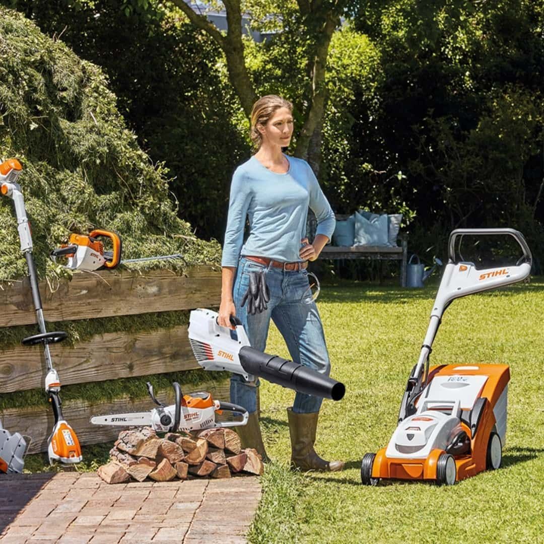 A Woman Is Standing Next To A Lawn Mower Holding A Blower — Coastal Farm & Motorcycles In Babinda, QLD