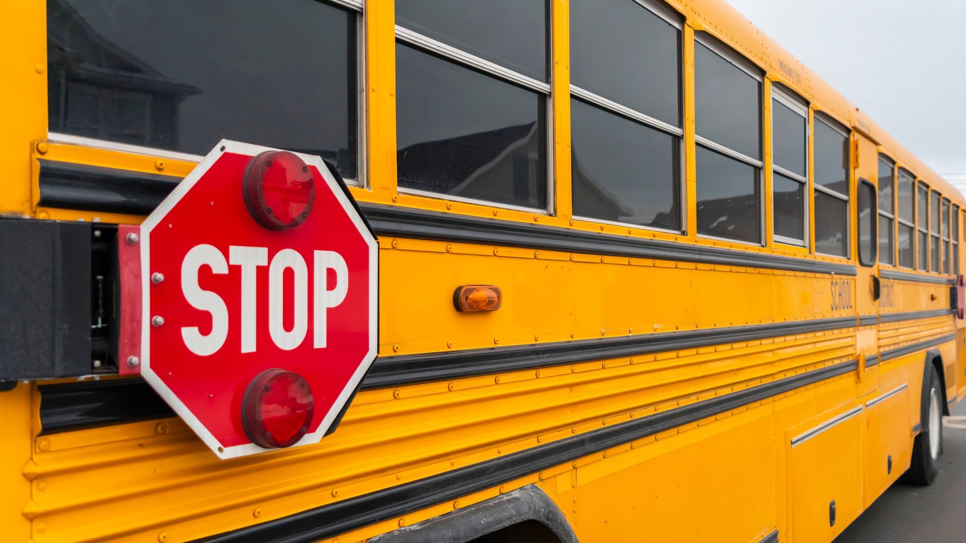 Yellow school bus with extended red STOP sign.