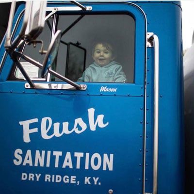 Child looking outside of septic truck