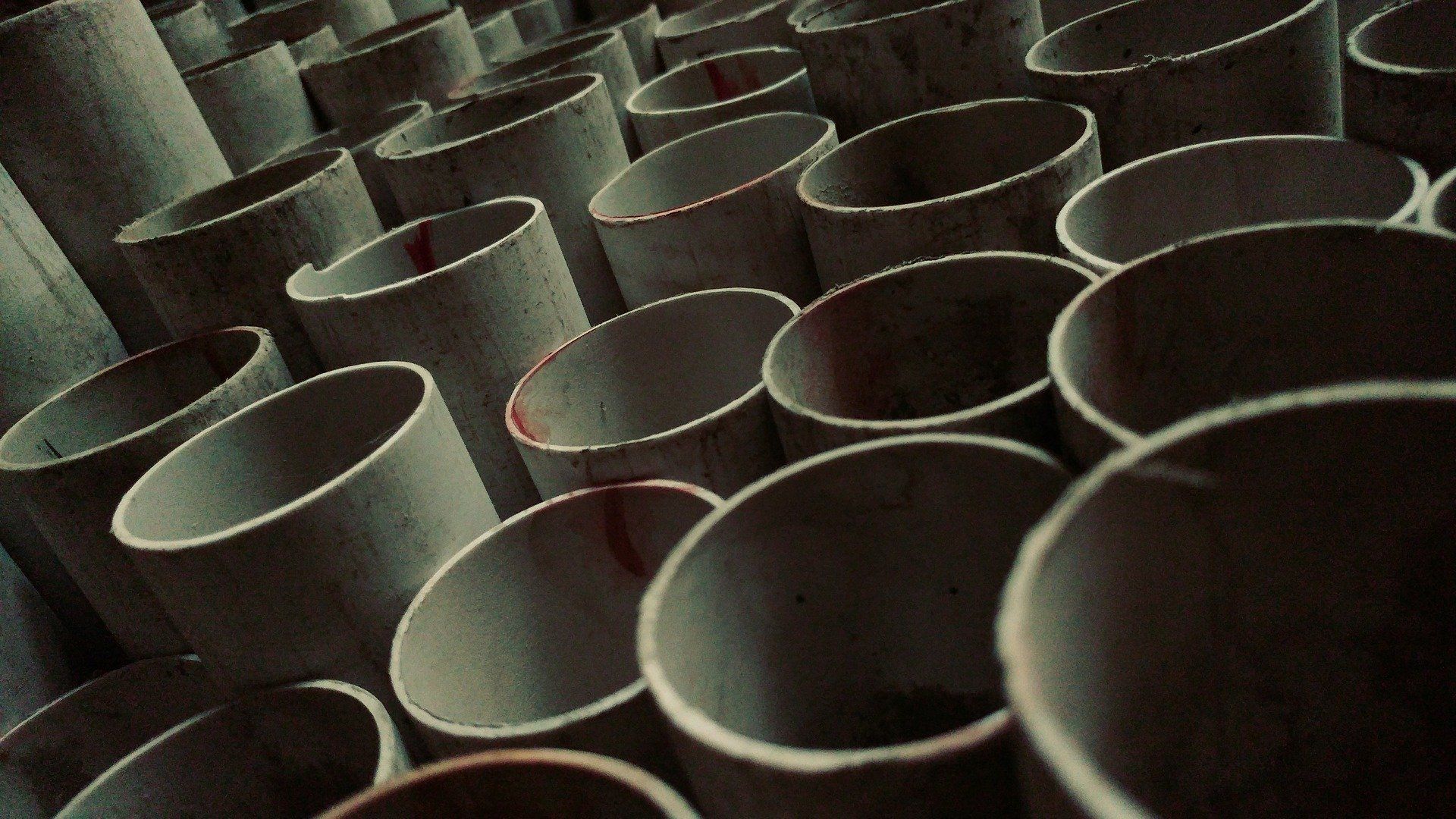 Rows of empty cardboard tubes viewed from above, creating a repeating circular pattern.