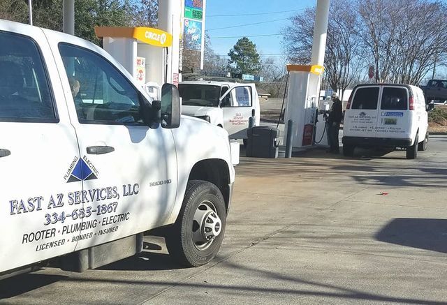 White service trucks parked at a gas station, including one with East AZ Services LLC lettering.