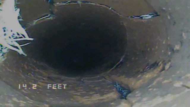 Pipe interior with dark circular opening and “14.2 FEET” measurement text