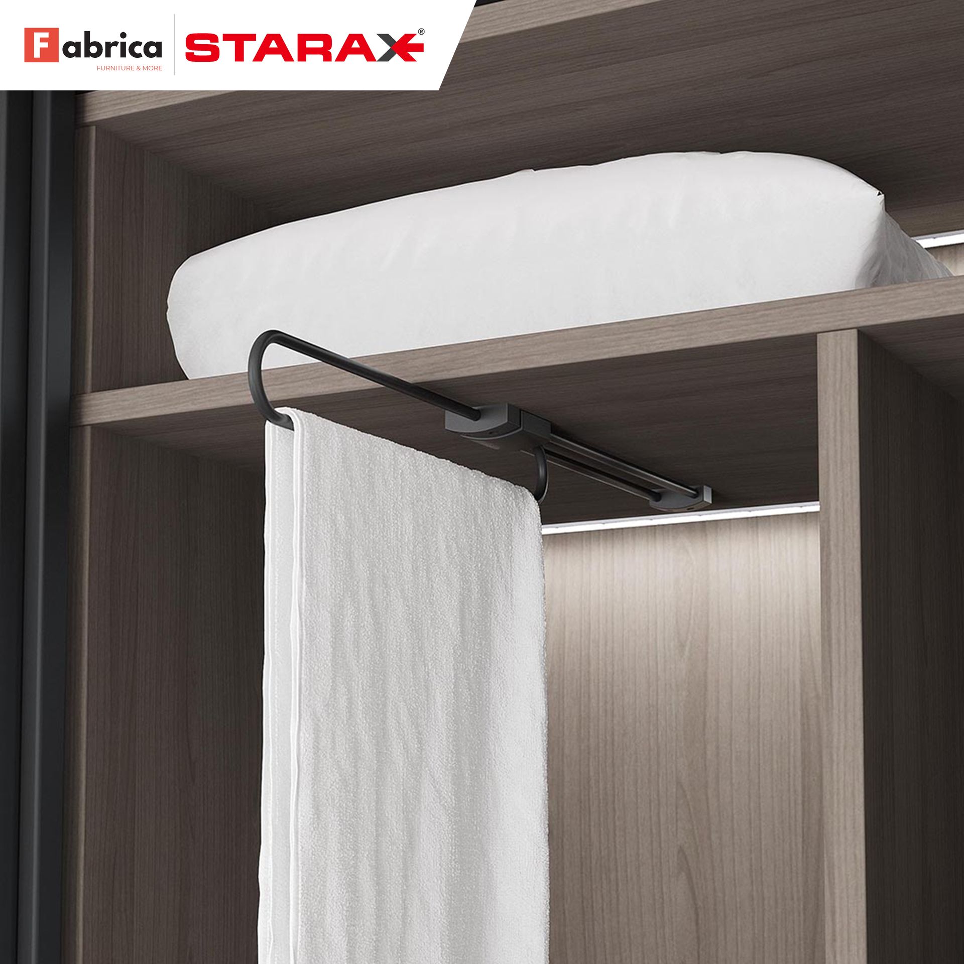 A white towel is hanging from a clothes rack in a closet.