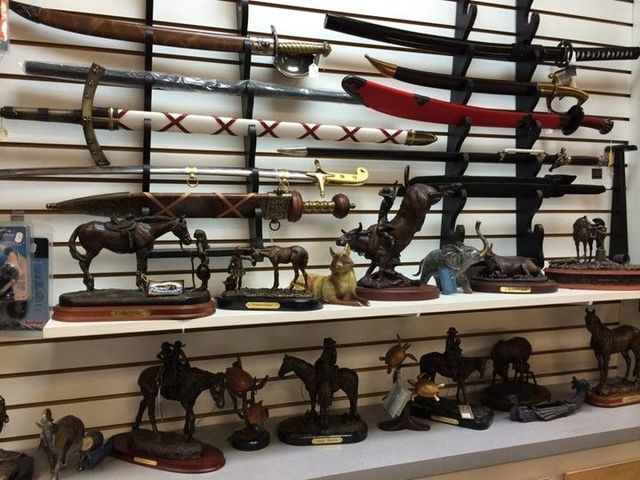 A display of swords and statues of horses