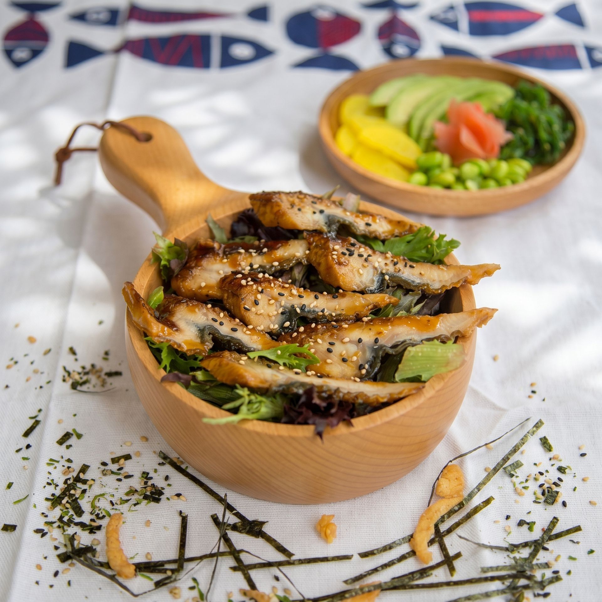 Grilled fish over greens in a wooden bowl, with sliced vegetables in the background