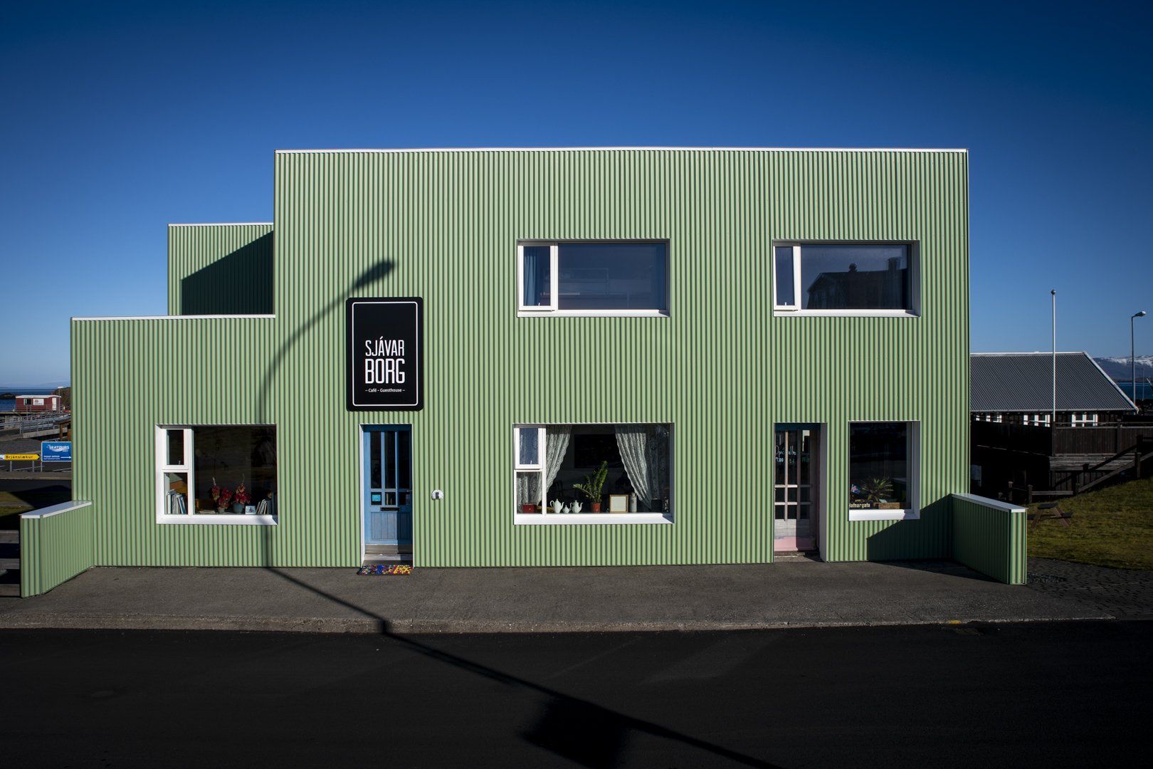 A green building with a sign that says ' cafe ' on it