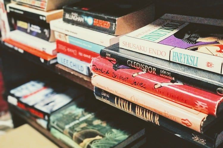 A stack of books on a shelf including one called gladiator