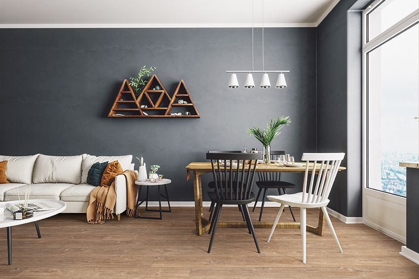 Un salon avec des murs rouges, une chaise, une lampe et une plante en pot.