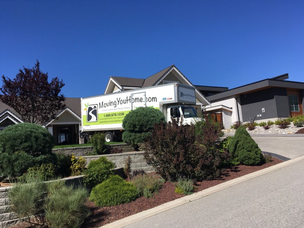 A moving truck is parked in front of a house.